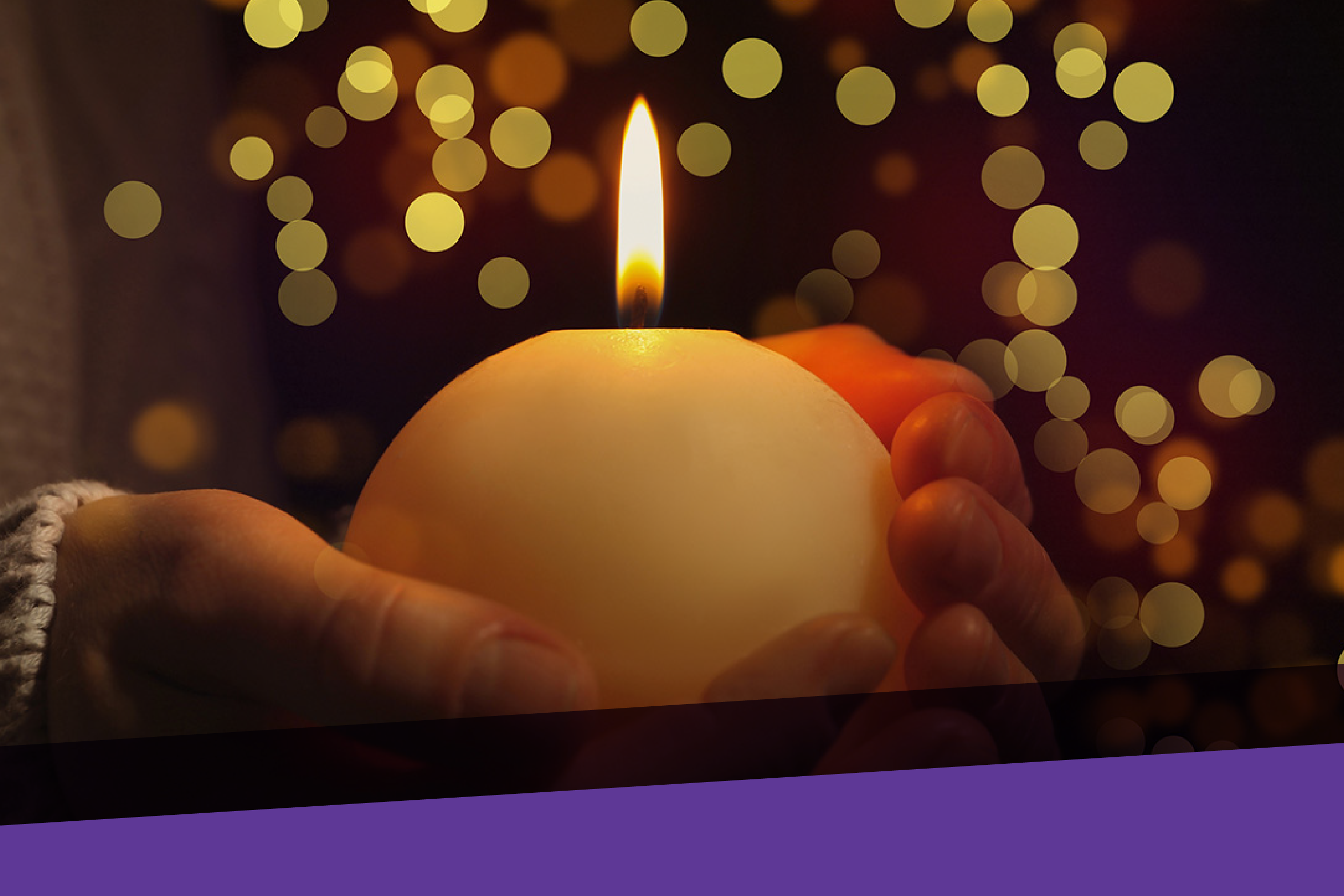 hands holding candle with holiday lights in background