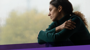 young woman looking out a window on a gloomy day