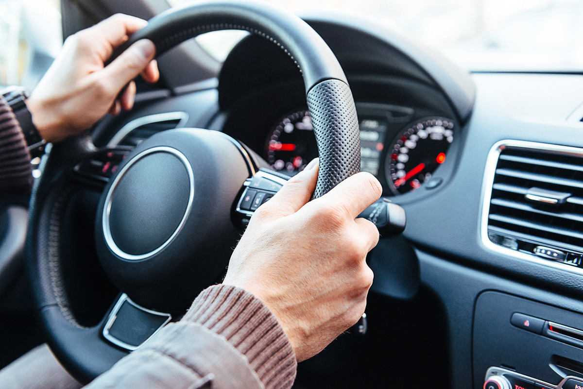 hands on steering wheel of car